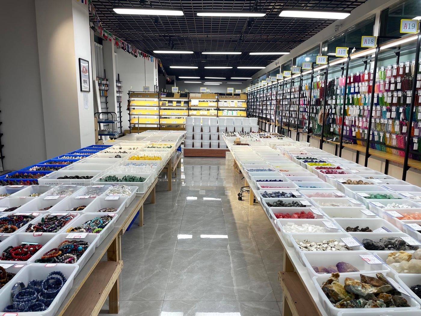 Stone selection hall at our partner atelier — trays of natural crystals and bead strands graded by hand